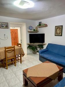 a living room with a blue couch and a table at Guest House Luli in Sarandë