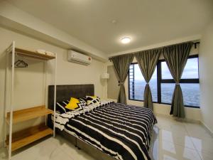 a bedroom with a black and white bed with windows at Arte Cheras Duplex Suites in Kuala Lumpur