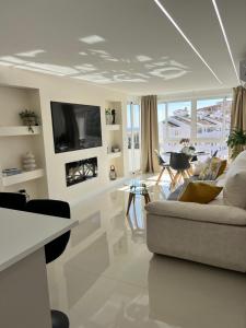 ein Wohnzimmer mit einem Sofa und einem TV in der Unterkunft Luxury Bonanza in Benalmádena