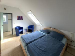sypialnia z łóżkiem i 2 niebieskimi krzesłami w obiekcie Flat 39 w mieście Wiehl