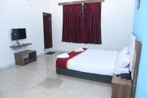 a bedroom with a bed and a tv and a bed sidx sidx sidx at PRC Residency in Chennai