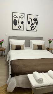 a bedroom with a large bed with three pictures on the wall at Sias Apartment in Alexandroupoli