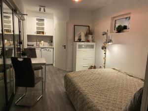 a bedroom with a bed and a desk and a kitchen at Studio Dorfblick in Fehmarn