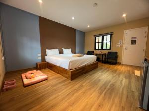 een slaapkamer met een bed, een bureau en een tafel bij Napdown Resort Trat นับดาว รีสอร์ท ตราด in Trat