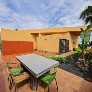 a patio with a table and chairs in front of a house at Villa Fortuna in Caleta De Fuste