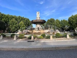 普罗旺斯艾克斯Joli Studio le clos d'Aix avec grande terrasse piscine et parking gratuit的公园中央的喷泉,有雕像