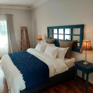 a bedroom with a large bed with a blue blanket at Art and Soul Restaurant, Accommodation, French Bar and Art Gallery in Parys