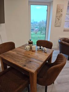 una mesa de madera en una habitación con sillas y una ventana en Ferienwohnung Boddenliebe, en Polchow