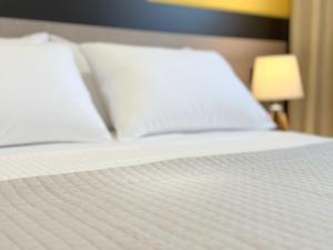 białe łóżko z dwoma poduszkami w obiekcie Home By The Sea - BRAND NEW w mieście Golem