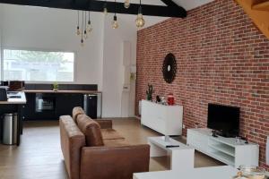 a living room with a couch and a brick wall at Atelier Détente in Liévin