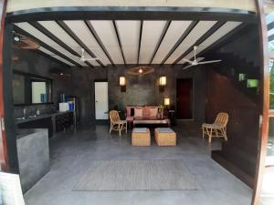 een woonkamer met een bank en een tafel en stoelen bij EL NIDO, Lugadia, Concrete House with Small Garden in El Nido
