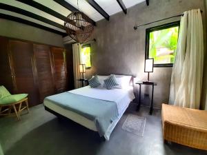 een slaapkamer met een groot bed en een raam bij EL NIDO, Lugadia, Concrete House with Small Garden in El Nido