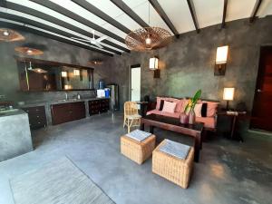 a living room with a couch and a table at EL NIDO, Lugadia, Concrete House with Small Garden in El Nido