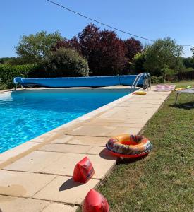 una piscina con un barco inflable al lado en Les Crozes, en Archignac