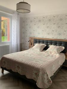 1 dormitorio con 1 cama con manta y ventana en Les Crozes, en Archignac