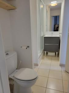 une salle de bain blanche avec toilettes et lavabo dans l'établissement appartement dans résidence avec piscine, à La Londe-les-Maures