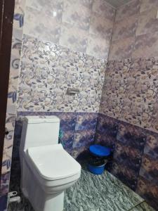 a bathroom with a toilet and a tiled wall at Kanchenjunga Homestay in Darjeeling