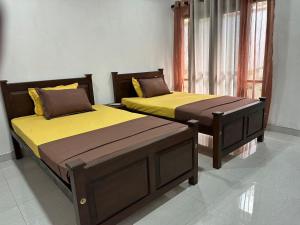 two beds sitting next to each other in a room at The Yellow in Talpe +19 photos