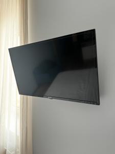 TV de pantalla plana colgada en la pared en Elys Aparthotel in Leipzig - Vollausgestattete Apartments mit Netflix, en Leipzig