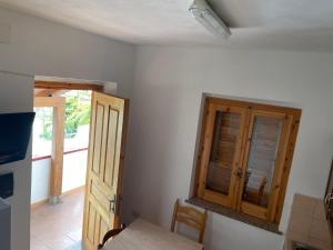 una cucina con armadio in legno, tavolo e porta di Villaggio Camping La Scogliera a Ricadi