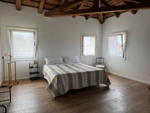 1 dormitorio blanco con 1 cama y 3 ventanas en Casa Toè Quinto, en Quinto di Treviso