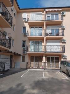 een appartementencomplex met balkons en een parkeerplaats bij Apartman ELIT in Veliko Gradište