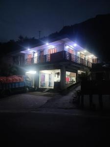 een huis met een balkon met verlichting bij Happy Morning Rohini Homestay in Kurseong