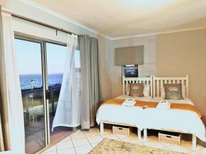 1 dormitorio con 1 cama y vistas al océano en Versveld 35, en Yzerfontein