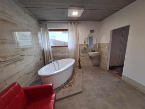 La salle de bains est pourvue d'une grande baignoire et d'un lavabo. dans l'établissement MARIE, à Zlín