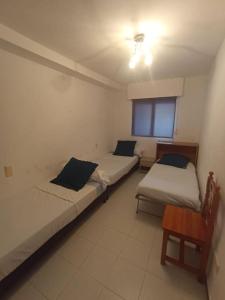 - 2 lits dans une petite chambre avec une table dans l'établissement logement tout confort marina or, à Oropesa del Mar