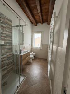 y baño con ducha de cristal y aseo. en Casa Toè Quinto, en Quinto di Treviso