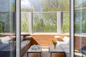 a living room with windows and a brick wall at River Exe Cottage waterfront in Exeter