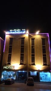 a hotel with a sign on top of it at night at داركم 2 للشقق المخدومة in Buraydah