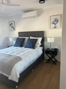 ein Schlafzimmer mit einem großen Bett mit blauen Kissen in der Unterkunft Apartment on Henry in North Ward