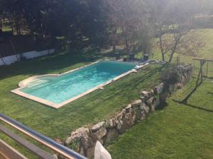 einen Pool in einem Garten mit einer Steinmauer in der Unterkunft MODERN VILLA IN COSTA BRAVA in Llagostera