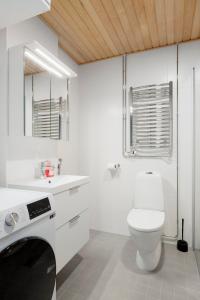 a white bathroom with a toilet and a sink at New 2BR design home with sauna Espoo Park in Espoo