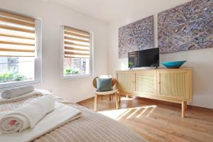 a bedroom with a bed and a tv and windows at Theater Apartment in Vračar (historical)