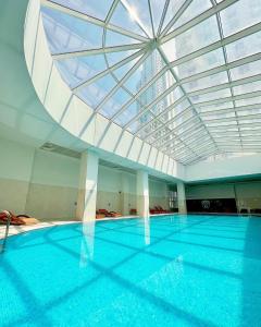 uma grande piscina com tecto de vidro em Sky View Apartment at Cevahir Sky City 32nd floor em Skopje