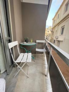 a balcony with two chairs and a table on a building at Enjoy Chania in Chania Town