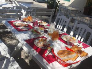 - une table avec des assiettes de nourriture et de boissons dans l'établissement L&G Hotel, à Vlorë