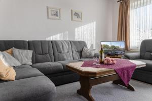 ein Wohnzimmer mit einem grauen Sofa und einem Tisch in der Unterkunft 50152... in Carolinensiel