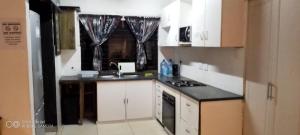 馬蓋特的住宿－Sea-Esta，厨房配有白色橱柜和黑色台面