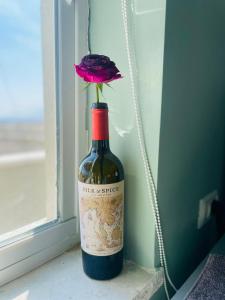 eine Flasche Wein mit einer Blume darin in der Unterkunft בין הר ובין ים in Ovnat
