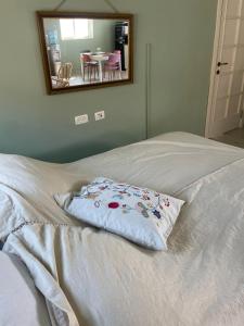 a pillow on top of a bed with a mirror at בין הר ובין ים in Ovnat