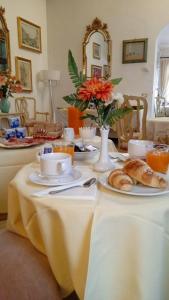 una mesa con platos de comida y cruasanes. en Ca' Riccio, en Venecia