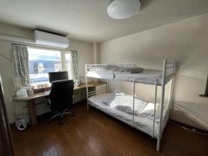 a room with two bunk beds and a desk with a computer at SharedHouse新琴似,駐車無料,予約要,最大6名,車で最寄り駅お迎え可能,麻生駅バス直通 in Sapporo