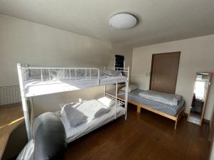 a room with two bunk beds in a room at SharedHouse新琴似,駐車無料,予約要,最大6名,車で最寄り駅お迎え可能,麻生駅バス直通 in Sapporo