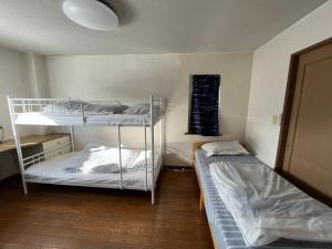 a room with two bunk beds in it at SharedHouse新琴似,駐車無料,予約要,最大6名,車で最寄り駅お迎え可能,麻生駅バス直通 in Sapporo