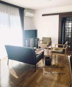 uma sala de estar com um sofá e duas cadeiras em Maison Peit Lapin メゾンプチラパン em Karuizawa