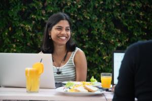 a woman sitting at a table with a plate of food at Safestay Pisa Centrale in Pisa